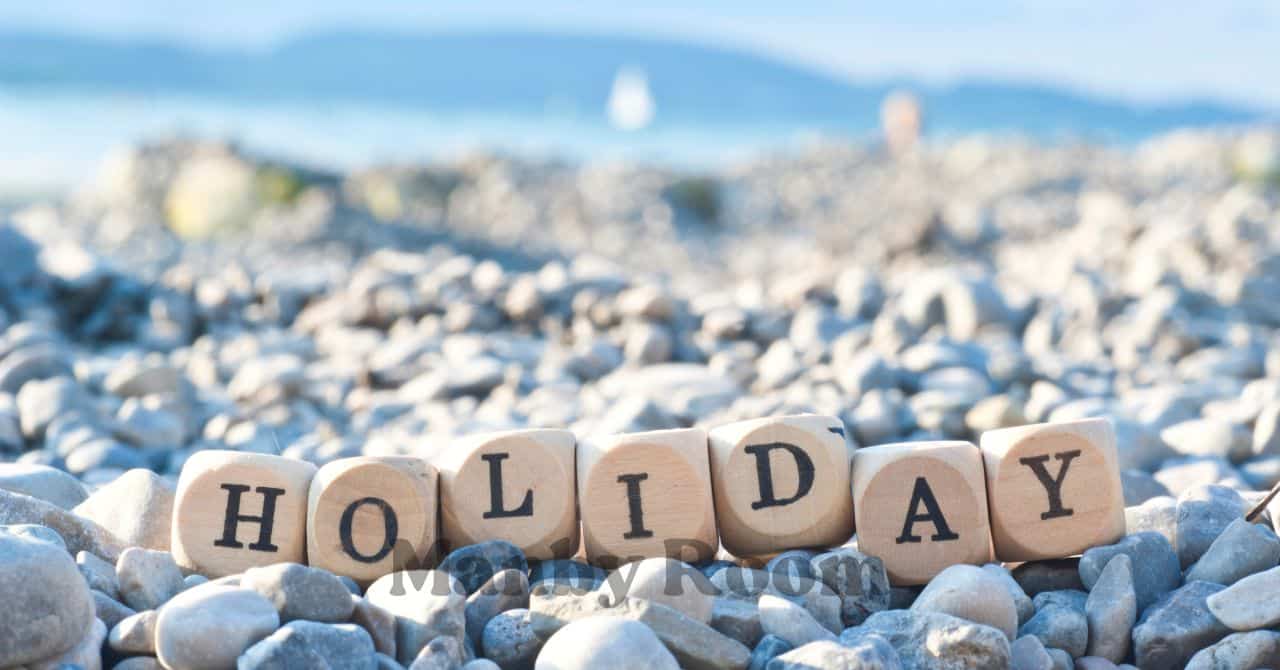 海辺の石の上に並べられた“HOLIDAY”の文字ブロック