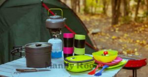 カラフルな食器や調理器具、ガスバーナーが並ぶキャンプテーブルの上の道具セット 