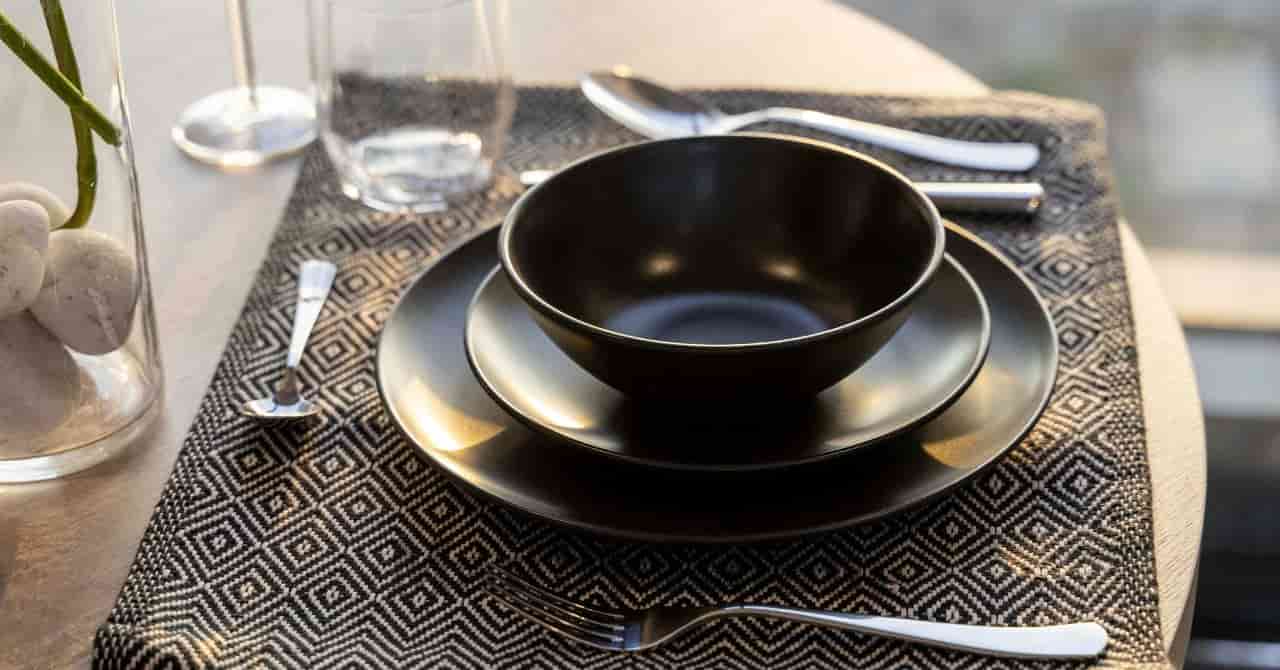 黒い食器が整然と並んだ、落ち着いた雰囲気のテーブルセッティング
