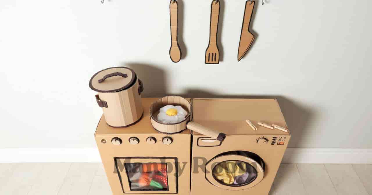 段ボールで作られたキッチンセットと壁にかかった調理器具で遊びの世界が広がる様子