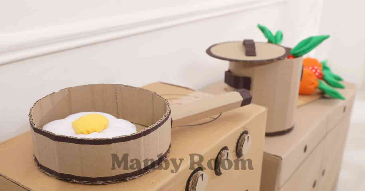 段ボールで作られたフライパンと鍋が並ぶ手作りキッチンの様子